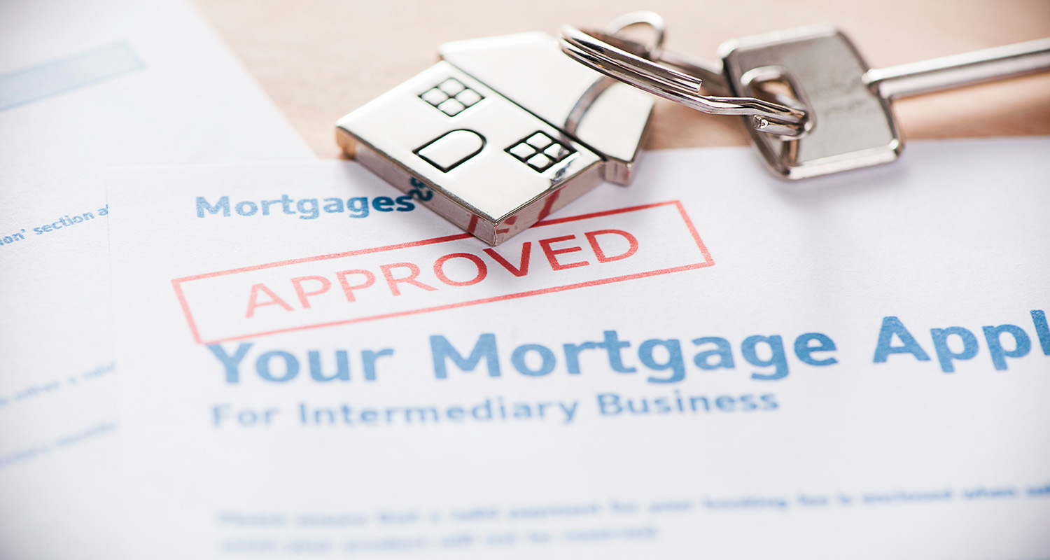 Mortgage papers with approval stamps with a set of keys on the paper